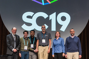 six people in front of a SC19 sign