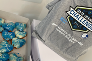 a box of donuts with "DSC" in icing, next to a DSC t-shirt