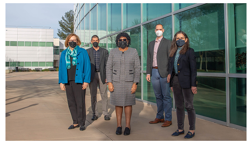 five people wearing masks and standing outside the HPC building