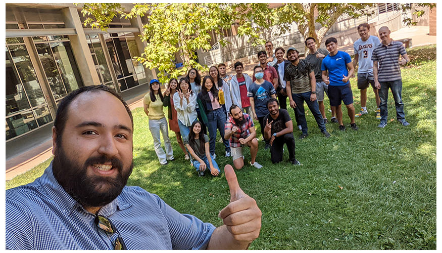 Vagelis gives a thumbs-up in the foreground while Brian and the students pose as a group behind him