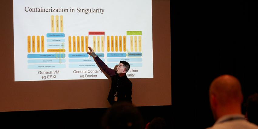 Ian Palmer points to a diagram as his presentation is projected on a big screen