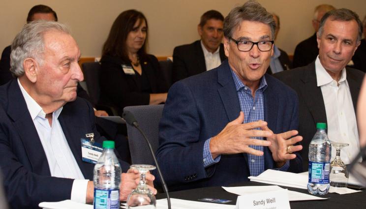 Rick Perry speaks to an audience at a table