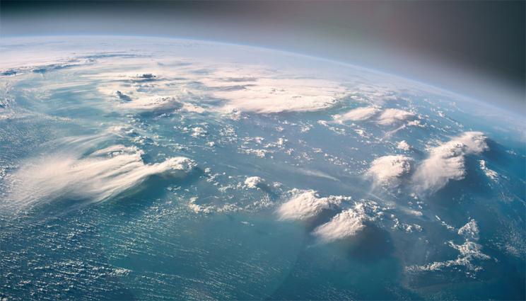 perspective of the earth from space with clouds over the ocean